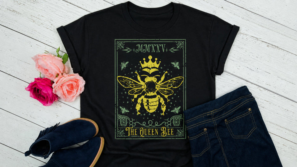 Queen Bee t-shirt on a wood plank bacground with roses and shoes