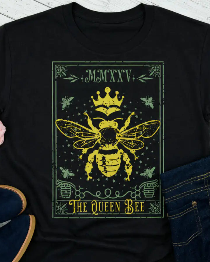 Queen Bee t-shirt on a wood plank bacground with roses and shoes