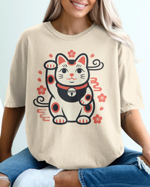 Tan t-shirt with a cartoon maneki-neko cat wearing a bell and flowers.