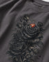 A close-up of a dark gray crewneck t-shirt featuring a detailed graphic print of black roses and a small red ladybug on the front.
