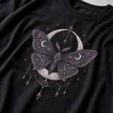 A close-up of a black t-shirt featuring a detailed gothic graphic of a moth with crescent moons and stars.