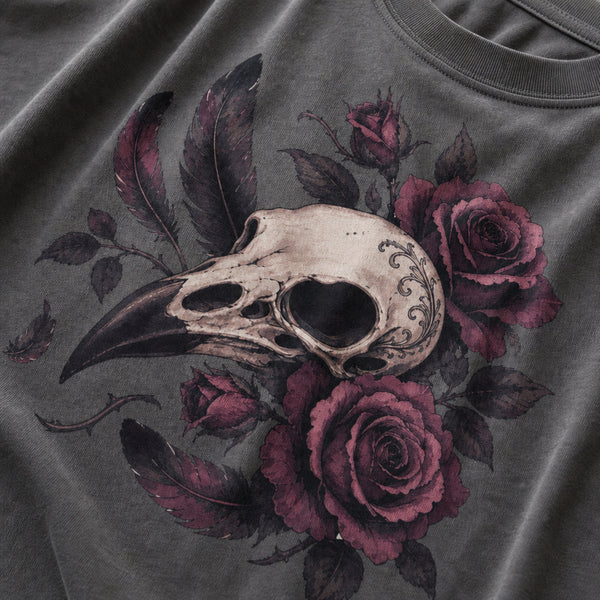 Close-up of a dark gray t-shirt featuring a detailed graphic print of a bird skull surrounded by dark purple roses and feathers.