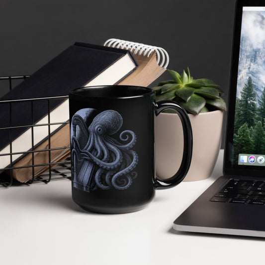 Black mug with octopus design on a desk with laptop and books