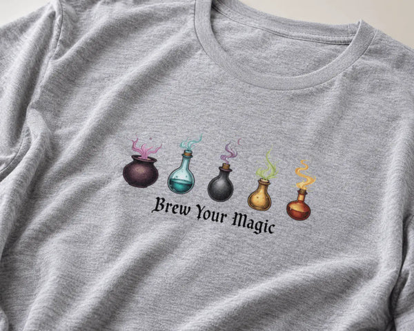 Gray t-shirt with colorful potion bottles and 'Brew Your Magic' text on a plain background 