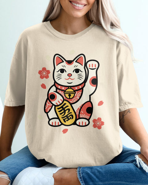 Cream t-shirt with a cartoon maneki-neko cat graphic and cherry blossoms.