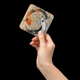 A hand holding a single Koi Coaster