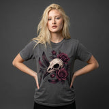 A blonde woman modeling a dark gray t-shirt with a graphic print of a bird skull and dark purple roses, posed against a dark gray studio background.