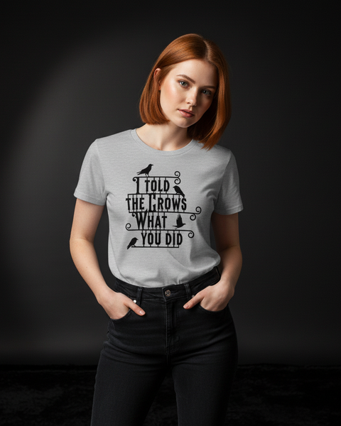 Woman wearing a gray t-shirt with the 'I told the crows' text and graphic design on a black background