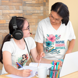Two people sitting at a table with one wearing headphones and the other holding a pen, both wearing t-shirts with designs.
