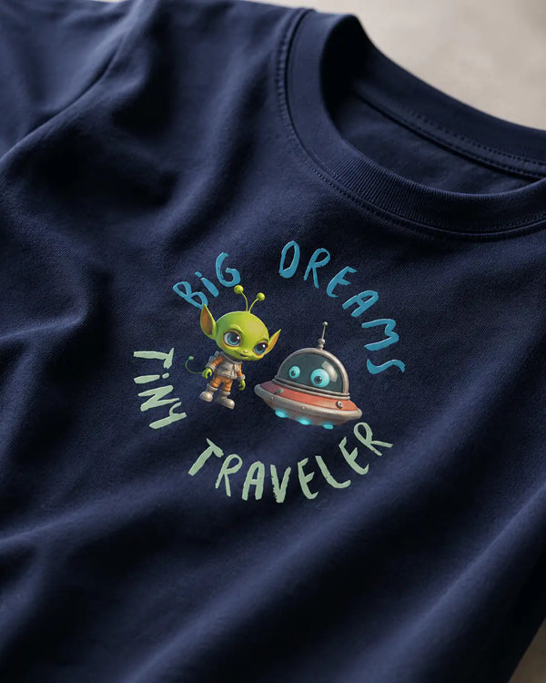 Navy blue t-shirt with alien and UFO design and text 'Big Dreams Tiny Traveler'. 
