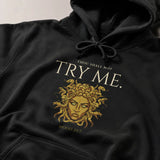 Black hoodie with gold Medusa design and text 'Thou shall not try me. Mood 24/7' on a neutral background 
