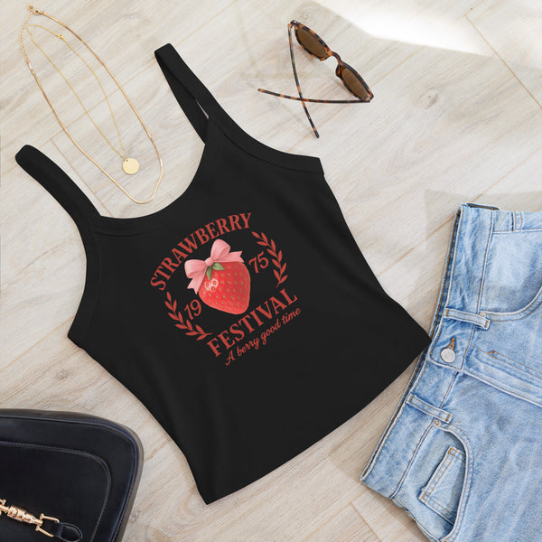 Black tank top with strawberry festival design on a light wooden surface with accessories.