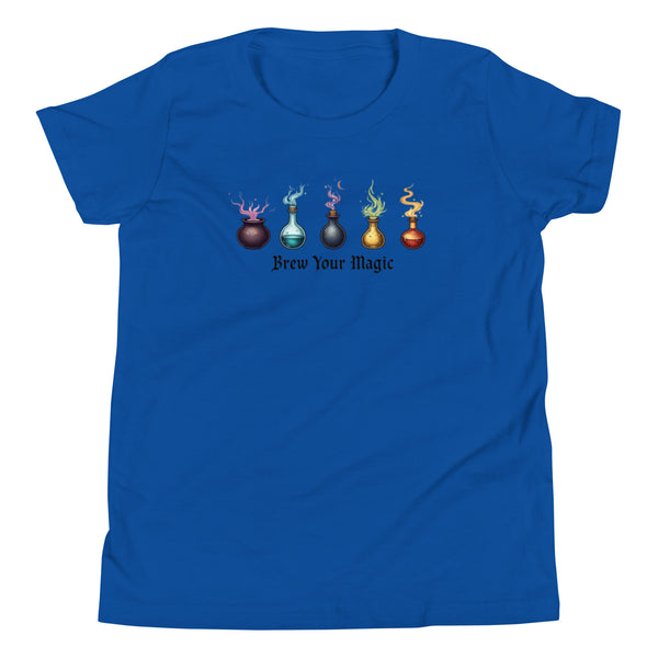A blue youth staple t-shirt displaying a graphic of five different colored potion bottles, each emitting a wisp of colored smoke. Below the bottles, the text "Brew Your Magic" is written in a dark, stylized font.